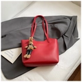 Dettaglio della borsa tote in pelle rossa con scritte dorate e ciondolo a forma di coniglio - Con Ciondolo / Rosso