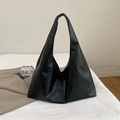 Minimalist large black faux leather tote bag for women featuring a wide shoulder strap - Black