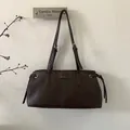 Details einer dunkelbraunen PU-Ledertasche mit Kordelzug-Akzenten und dem MUTING-Markenlogo - Braun