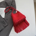 Red suede shoulder bag with long fringes and rope strap on grey blazer - Red