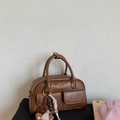 Close-up of vintage brown Boston bag with dual flap pockets and a cute bear charm - Yellow Brown With Pendant
