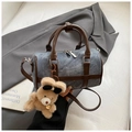 Détail du sac polochon en denim avec finitions cuir marron et pendentif ourson - Bleu avec Pendentif