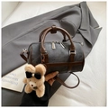Détail du sac Boston en denim gris avec garniture en cuir et breloque ours en peluche - Noir avec pendentif