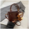 Sac seau en cuir marron foncé avec logo doré et charmant petit ours en peluche marron - Marron avec pendentif