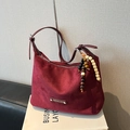 Deep burgundy suede tote bag featuring a decorative beaded tassel and metal emblem - Purplish Red With Charm