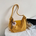 Details einer senfgelben Wildleder-Schultertasche mit niedlichem Schaf-Anhänger und Schnalle - Gelb mit Anhänger
