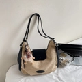 Detail der khakifarbener Wildleder-Hobo-Tasche mit schwarzer Klappe und Alpaka-Anhänger - Camel Mit Anhänger