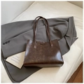 Deep brown vintage faux leather tote bag with glossy texture on a grey suit jacket - Coffee without Pendant