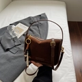 Details der Nähte aus dunkelbraunem Wildleder und goldener Beschläge der Modetasche - Braun