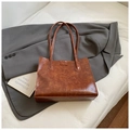 Close-up of vintage brown PU leather tote bag with vertical stitching on a grey blazer - Brown No Pendant