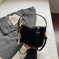 Detail der minimalistischen schwarzen Wildleder- und Lederhandtasche mit Goldbeschlägen - Schwarz