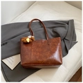Close-up of brown faux leather tote bag with vintage texture and plush bear charm - Brown with Pendant