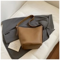 Brown leather bucket bag with pebble texture styled on a grey blazer for a chic look - Khaki