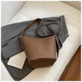 Detailed view of the brown lychee pattern leather bucket bag with wide shoulder strap - Brown