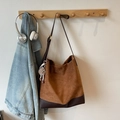 Brown suede tote bag with plush keychain hanging on a wooden hook in a lifestyle setting - With Charm / Brown
