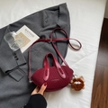 Dettaglio della borsa a secchiello in maglia bordeaux con tracolla e ciondolo - Rosso Vino con Pendente