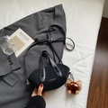 Dettaglio borsa a secchiello nera intrecciata con tracolla in pelle e ciondolo peluche - nero con ciondolo