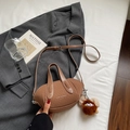 Dettaglio mini borsa a secchiello in pelle marrone con tracolla e ciondolo di peluche - Marrone con ciondolo