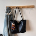 Minimalist black tote bag with vintage texture and cute bear charm on a wall hanger - Black With Pendant