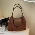 Dettaglio della borsa tote marrone vintage con trama scamosciata e fibbia metallica tonda - caffè