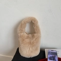 Detailed close-up of fluffy beige faux fur texture on a stylish bucket handbag - Khaki