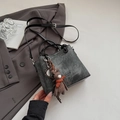 Detail of dark grey suede crossbody bag with round handle and plush bunny charm - With Pendant / Black