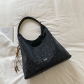 Detalle del bolso tote de lona negra con borla de cuentas de madera y logo de la marca - Negro