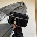 Black suede crossbody bag with a signature silver robot pendant and adjustable strap - Black
