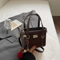 Bolso tipo cubo de ante marrón oscuro con asas de cuero y colgantes suaves - Marrón