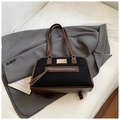 Dettaglio della borsa tote in nabuk nero con finiture in pelle marrone e inserti dorati - Nero