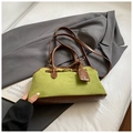 Borsa Boston retrò in camoscio verde e pelle marrone su sfondo di abito grigio - Verde
