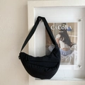 Detail view of black quilted crossbody bag with adjustable strap and double zipper finish - Black