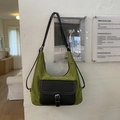 Detail der grünen Wildleder-Hobo-Tasche mit schwarzer Lederklappe und weißer Steppnaht - Grün