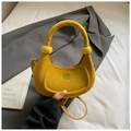 Detalle de un bolso de media luna amarillo brillante con textura de ante y asa redonda - Amarillo