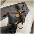Detalle de bolso bandolera de ante azul con ribete de cuero marrón y placa de metal dorada - Azul