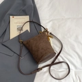Brown quilted bucket bag with suede texture, top handle, and beaded tassel accessory - With Charm / Brown