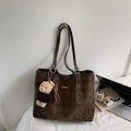 Detailaufnahme der gesteppten Kaffeetasche mit Bärenanhänger und Laptop für das Büro - Schlamm mit Anhänger