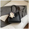 Minimalist black lychee textured tote bag with a plush bear charm for daily commute - Vertical Black With Pendant