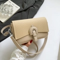 Retro minimalist beige leather crossbody bag with buckle detail held in hand - Khaki