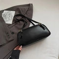 Chic black matte leather baguette bag with adjustable straps in a minimalist setting - Black