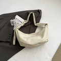 Chic cream white crescent dumpling bag with adjustable strap on a grey blazer background - Off White