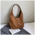 Close-up of brown suede hobo bag with laser-cut floral patterns and smooth leather handle - Brown