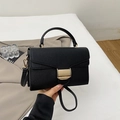 Detail of black lychee grain leather handbag with gold metal clasp and detachable strap - Black