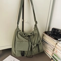 Large army green drawstring canvas bucket bag hanging on a door in a lifestyle setting - Green