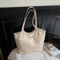 Detalle del bolso tote crema con placa dorada y textura de cuero sintético - Blanco Roto