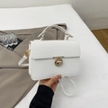Close-up of white lychee leather square handbag with golden turn-lock and crossbody strap - White