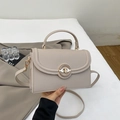 Detail view of lychee pattern leather shoulder bag with golden metal circular ring lock - Khaki
