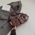Detailaufnahme der dunkelbraunen Biker-Schultertasche mit Metall-Reißverschlüssen - Braun