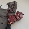 Nahaufnahme der weinroten Vintage-Motorradtasche mit Metallreißverschlüssen und Nieten - Rot