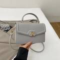 Close-up of gray lychee pattern leather handbag with gold twist lock and handle - Gray